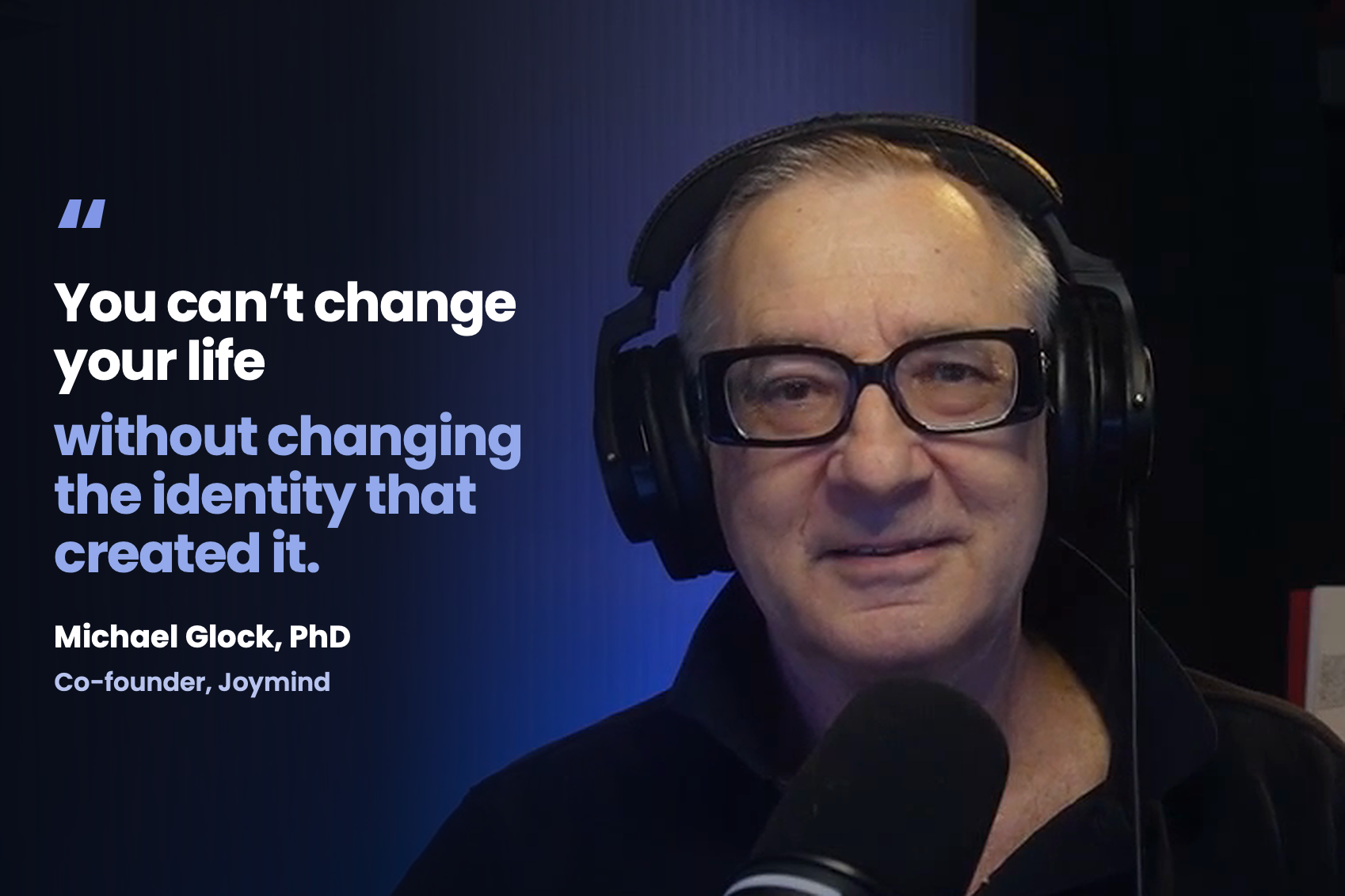 Michael Glock, PhD, co-founder of Joymind, smiling at the camera in his library during the Redefining Wisdom podcast, with the words “You can’t change your life without changing the identity that created it.”
